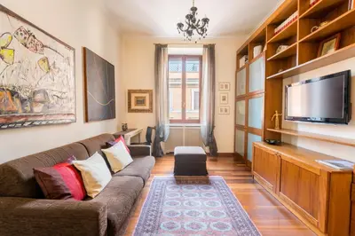 a living room with a couch and a flat screen tv at Dimora Esedra, Historical Flat in the Heart of Rome in Rome