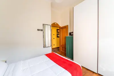 a bedroom with a white bed with a red blanket at Dimora Esedra, Historical Flat in the Heart of Rome in Rome