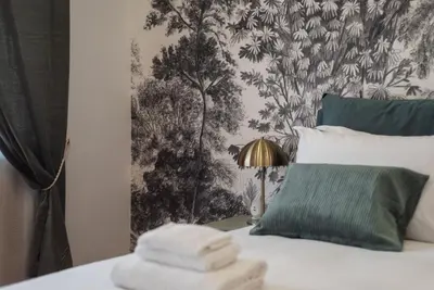 a bedroom with a bed with a green and grey wallpaper at Casa Incanto - Luxury Vatican Apartment in Rome
