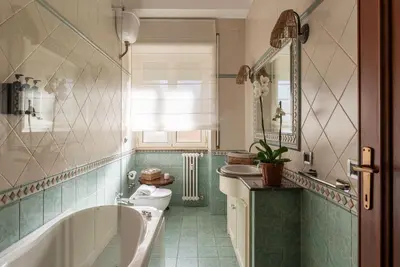 a hallway with a green cabinet and a vase of flowers at Casa Incanto - Luxury Vatican Apartment in Rome