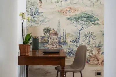 a desk with a chair in front of a wall mural at Casa Incanto - Luxury Vatican Apartment in Rome