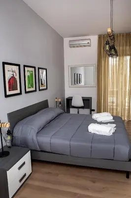 a bedroom with a large bed with blue sheets at Ostiense 73 in Rome