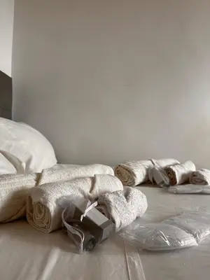 a bed with white blankets and towels on the floor at Porta Maggiore room in Rome