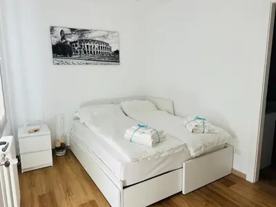 a white bed in a room with a picture on the wall at Appartamento Lilly's Home Piazza Navona in Rome