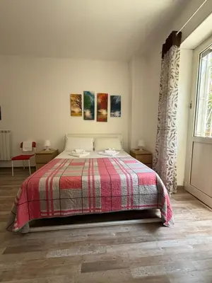 a bedroom with a bed with a red and white blanket at Room CasaVostrA 2 in Rome