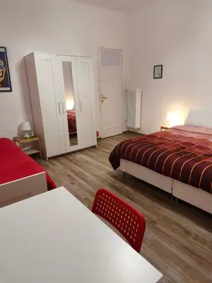 a bedroom with two beds and a table and a chair at Room CasaVostrA 2 in Rome