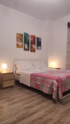 a bedroom with a bed and two night stands and two lamps at Room CasaVostrA 2 in Rome