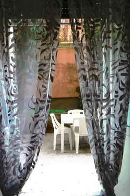 a room with a table and chairs and a curtain at Room CasaVostrA 2 in Rome
