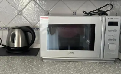 a microwave sitting on a counter next to a coffee pot at ULPIANO SUITE Vaticano Centro in Rome