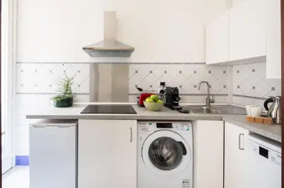 a kitchen with a washing machine and a sink at ULPIANO SUITE Vaticano Centro in Rome