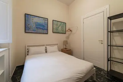 a bedroom with a bed and two pictures on the wall at JOIVY Charming 3BR flat near the Vatican in Rome