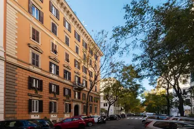 a building with cars parked on the side of a street at JOIVY Charming 3BR flat near the Vatican in Rome
