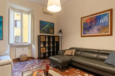 a living room with a leather couch and a table at JOIVY Charming 3BR flat near the Vatican in Rome