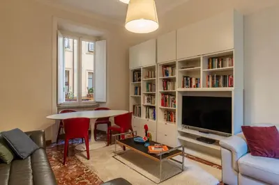 a living room with a couch and a table and a tv at JOIVY Charming 3BR flat near the Vatican in Rome