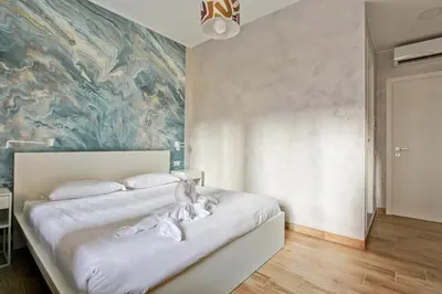 a bedroom with a bed with a painting on the wall at Marble Rooms in Rome