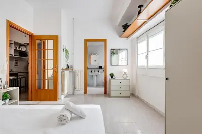 a white room with a bed and a bathroom at Casa San Paolo in Rome