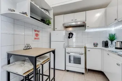 a kitchen with white appliances and a wooden table at Casa San Paolo in Rome