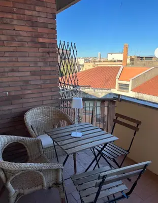 a wooden table and chairs on a balcony with a view at San Paolo Corner in Rome