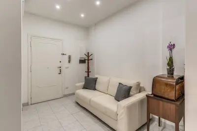 a white living room with a couch and a table at Nina's Apartment with terrace Rome Monteverde in Rome