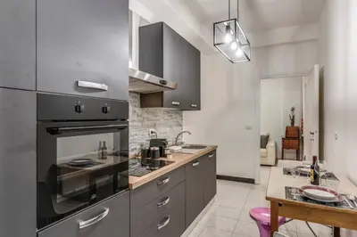 a kitchen with stainless steel appliances and a table at Nina's Apartment with terrace Rome Monteverde in Rome
