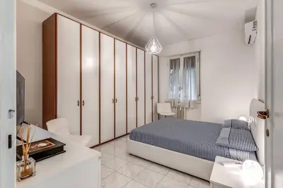a white bedroom with a bed and a table and chairs at Nina's Apartment with terrace Rome Monteverde in Rome