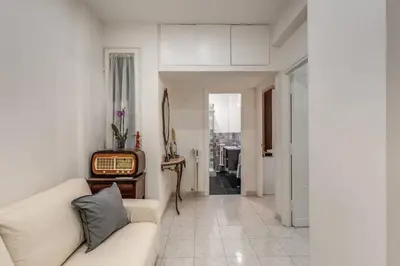 a living room with a white couch and a tv at Nina's Apartment with terrace Rome Monteverde in Rome