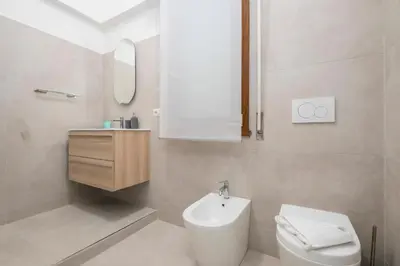 a white bathroom with a sink and a toilet at Zen Vatican Studio - Zen 30 in Rome