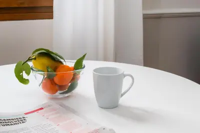 a bowl of fruit on a table next to a cup at Zen Vatican Studio - Zen 30 in Rome