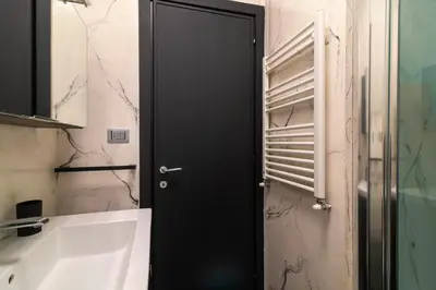 a black door in a bathroom next to a sink at Aim - La Cupola - Saint Peter view apartment in Rome