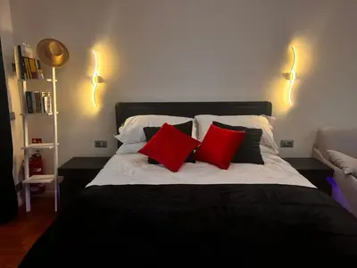 a bedroom with a bed with two red pillows at Aim - La Cupola - Saint Peter view apartment in Rome