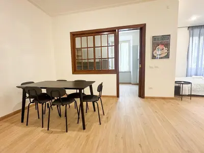 a dining room with a black table and chairs at Mocenigo Boutique Apartment in Rome