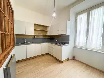 an empty kitchen with white cabinets and a window at Mocenigo Boutique Apartment in Rome