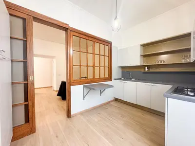 a kitchen with white cabinets and a bench in it at Mocenigo Boutique Apartment in Rome