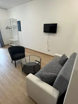 a living room with a couch and a tv on a wall at Mocenigo Boutique Apartment in Rome