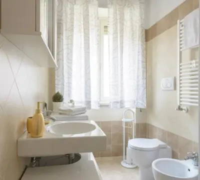 a bathroom with a sink and a toilet and a window at Casetta Maria Pia near Metro A Cornelia in Rome