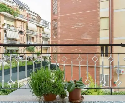 a balcony with potted plants in front of a building at Casetta Maria Pia near Metro A Cornelia in Rome