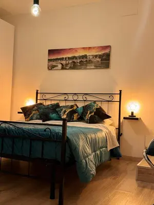 a bedroom with a bed and a painting on the wall at suite Colosseo in Rome