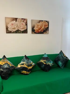 a green couch with four pictures on the wall at suite Colosseo in Rome