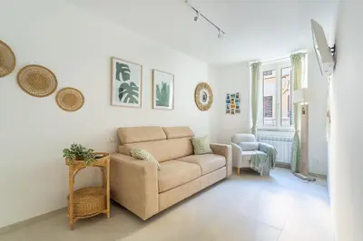 a living room with a couch and a chair at Iflat New Cozy Retreat Near the Colosseum in Rome