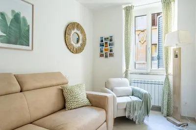 a living room with a couch and a chair at Iflat New Cozy Retreat Near the Colosseum in Rome