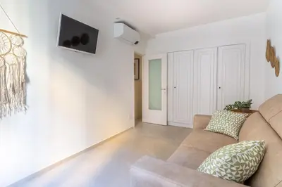 a living room with a couch and a tv on a wall at Iflat New Cozy Retreat Near the Colosseum in Rome