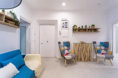 a living room with a blue couch and two chairs at Iflat New Cozy Retreat Near the Colosseum in Rome