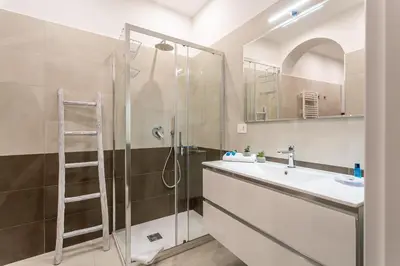 a bathroom with a shower and a sink and a ladder at Iflat New Cozy Retreat Near the Colosseum in Rome