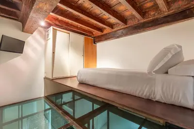a bed sitting on top of a table with a glass floor at Navona Stylish Apartment - Up to 5 People in Rome