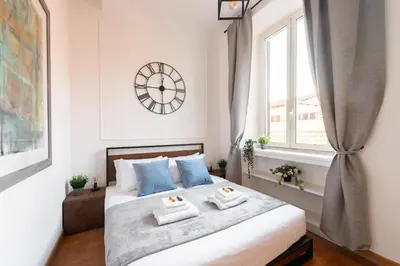 a bedroom with a large bed with a clock on the wall at Appartamento Via XXIV Maggio in Rome