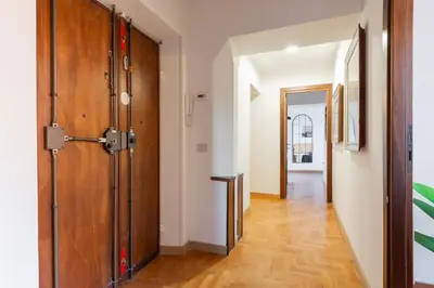 a hallway with a wooden door and a wooden floor at Appartamento Via XXIV Maggio in Rome