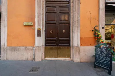 a building with a brown door with a sign in front at Appartamento Via XXIV Maggio in Rome