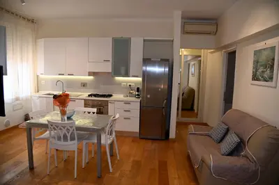 a kitchen and living room with a table and a couch at Casetta via delle Cave in Rome