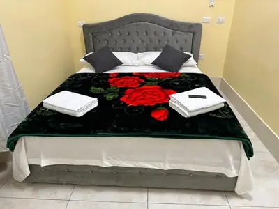 a bed with a black blanket with red roses on it at TURATI TERMINi in Rome