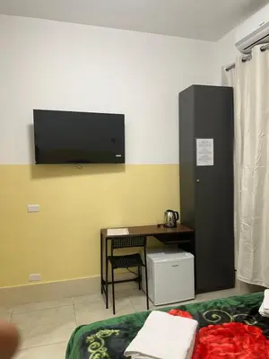 a room with a desk and a tv on the wall at TURATI TERMINi in Rome
